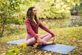 Young woman doing yoga exercise outdoor in the park near lake, sport yoga concept Royalty Free Stock Photo