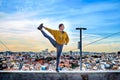 Young woman doing yoga exercise outdoors on the Lisbon city view background