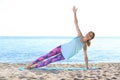 Young woman doing yoga exercises on beach Royalty Free Stock Photo