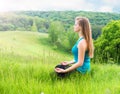 Young Woman doing Yoga Exercises Outdoor. Beautiful Girl practicing yoga in the park. Royalty Free Stock Photo