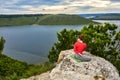 Young woman is doing yoga exercises on the rock above beautiful river. Royalty Free Stock Photo