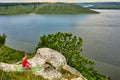 Young woman is doing yoga exercises on the rock above beautiful river. Royalty Free Stock Photo