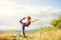 Young woman doing yoga or fitness exercise outdoor, nature landscape at sunset. Royalty Free Stock Photo