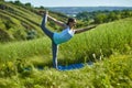 Young woman doing yoga in green summer meadow Royalty Free Stock Photo