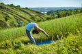 Young woman doing yoga in green summer meadow Royalty Free Stock Photo