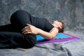 Young woman doing yoga laying down doing yoga twis