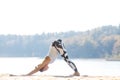 Young woman doing yoga near lake outdoors, meditation. Sport fitness and exercising in nature. Autumn sunset. Royalty Free Stock Photo