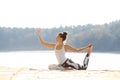 Young woman doing yoga near lake outdoors, meditation. Sport fitness and exercising in nature. Autumn sunset. Royalty Free Stock Photo