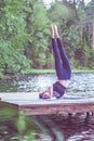 Young woman doing yoga on the pier of a beautiful lake.  Concept of healthy life Royalty Free Stock Photo