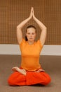 Young woman doing yoga in the sunny room