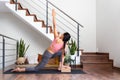 Young woman doing yoga twist at home using cork yoga block. Copy space.