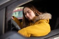 Young woman with Down syndrome driving a car and looking at camera. Royalty Free Stock Photo