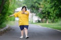 young woman with down syndrome exercising by walking to burn fat and running slowly fat young woman exercising in the park in the