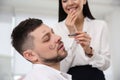 Young woman drawing on colleague`s face while he sleeping in office. Funny joke Royalty Free Stock Photo