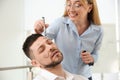 Young woman drawing on colleague`s face while he sleeping in office. Funny joke Royalty Free Stock Photo