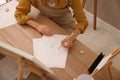 Young woman drawing female portrait at table indoors, above view