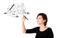 Young woman drawing a house on whiteboard Royalty Free Stock Photo
