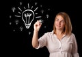 Woman drawing light bulb on whiteboard Royalty Free Stock Photo