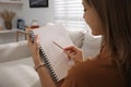 Young woman drawing in sketchbook with pencil at home Royalty Free Stock Photo