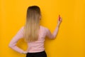 Young Woman Is Drawing On A Yellow Wall, Rear View