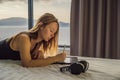 Young woman draws on a tablet against the background of a window with a sea view. Designer, sketching Royalty Free Stock Photo