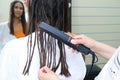 Young woman with dreadlocks. false dreadlocks on the curling iron Royalty Free Stock Photo