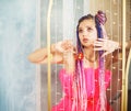 young woman with dreadlocks hairstyle wearing pink dress, doll style, bright make, up in the pink room. Royalty Free Stock Photo