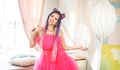 young woman with dreadlocks hairstyle wearing pink dress, doll style, bright make, up in the pink room. Royalty Free Stock Photo