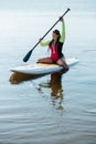 Young Woman with Dreadlocks in Swimwear Sitting on the Sup Board, Female Paddleboarding on the Lake at Sunrise