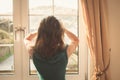Young woman in dress looking out the window Royalty Free Stock Photo