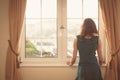 Young woman in dress looking out the window Royalty Free Stock Photo