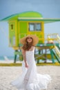 Young woman in dress on south beach miami. Beautiful girl on summer vacation. Happy traveller woman in white dress