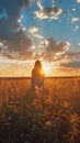 Young woman in a dress standing in the middles of serene meadow with sun on horizon and puffy clouds in the sky. Comfort