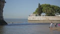 Young woman in dress walking shoeless in water at