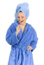 Young woman dressed blue bathrobe brushing teeth Royalty Free Stock Photo