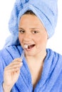 Young woman dressed blue bathrobe brushing teeth Royalty Free Stock Photo