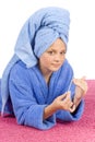 Young woman dressed blue bathrobe and towel filing nails Royalty Free Stock Photo