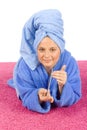 Young woman dressed blue bathrobe and towel filing nails Royalty Free Stock Photo