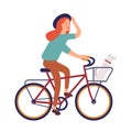 Young woman dressed in casual clothes riding bike. Cute hipster girl on bicycle with dog sitting in basket. Pedaling Royalty Free Stock Photo