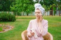 Young woman dressed for shower towel wrapped head for hair hold in bottles Royalty Free Stock Photo