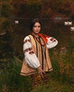 Young woman dressed traditional ukrainian embroidered clothes. Portrait of beautiful confident girl with long dark hair and brown Royalty Free Stock Photo