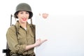 Young woman dressed in ww2 military us uniform with helmet showi Royalty Free Stock Photo