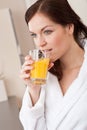 Young woman drink orange juice in kitchen