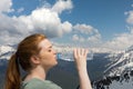 Young woman drink water from plastic bottle in the mountains on the snow peaks background Royalty Free Stock Photo