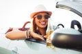 Young woman drinking a beer and looking the sunset. She is sitting in a sportive car. Royalty Free Stock Photo