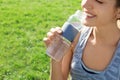 Young woman drinking clean water from bottle outdoors Royalty Free Stock Photo