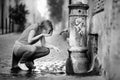 Young woman drinking clean water from the fountain in Rome, Italy Royalty Free Stock Photo