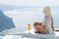 Young woman drinking a cocktail enjoying a magnificent view of Santorini near the pool Royalty Free Stock Photo