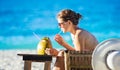 Young woman drinking coconut juice while relaxing