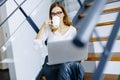 Young woman drinking coffe and working on laptop in office Royalty Free Stock Photo